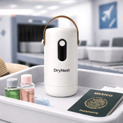 Secador portátil DryNest colocado en bandeja de control de seguridad del aeropuerto, ideal para viajar